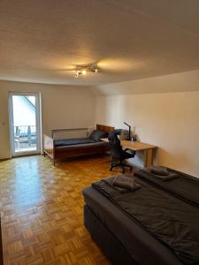 クルムバハにあるSchöne NEU Renovierte Ferienwohnungのベッド2台、デスク、ソファが備わる客室です。