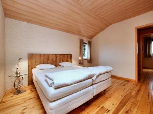 a bedroom with a large white bed and wooden floors at Cosy Nature Retreat, Houffalize in Houffalize