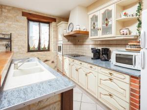une cuisine avec un évier et un micro-ondes dans l'établissement Cosy holiday home near the Causses du Quercy, à Lavercantière