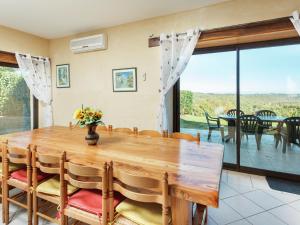 une salle à manger avec une table en bois et une grande fenêtre dans l'établissement Cosy holiday home near the Causses du Quercy, à Lavercantière