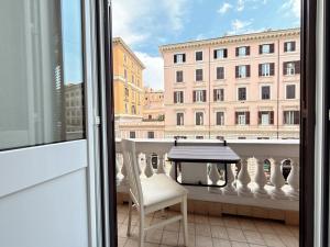 a table and a chair on a balcony with a view at Luxe roma in Rome