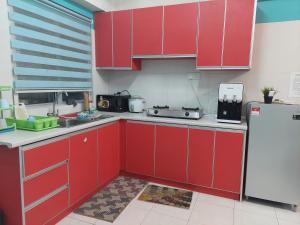 cocina con armarios rojos y nevera en Anis Homestay Bangi, en Bangi 5 fotos más