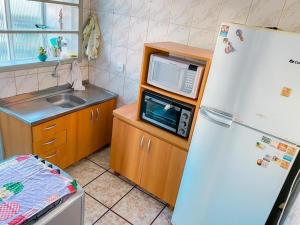 a kitchen with a microwave on a counter next to a refrigerator at Apartamento Torres in Torres