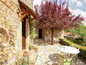 a patio with a table and a tree at Lakeside Cottage Roziers Retreat in Lissac-sur-Couze