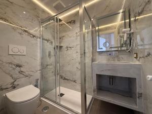 a bathroom with a toilet and a glass shower at Luxe roma in Rome +64 photos