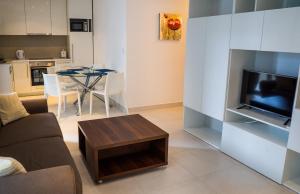 ein Wohnzimmer mit einem Sofa und einem Tisch in der Unterkunft Apartments Belmont Becici in Budva