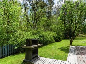 a stone bench in a garden with trees and grass at Sunny Garden Cottage, Alle in Frahan