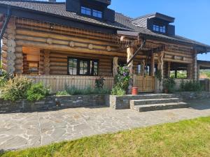 a log home with a patio in front of it at Bordeiul Legionarilor in Vatra Dornei