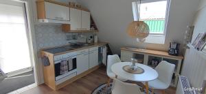 a small kitchen with a table and a table and chairs at Uns Lüttje in Norden