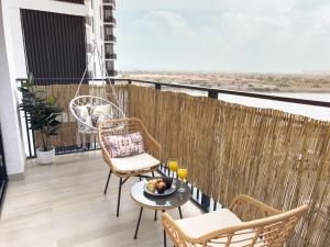 a balcony with chairs and a table with food on it at Luxury Retreat 1BDR Apartment in Yas Island Premium Location with Pool and Gym in Yas Island
