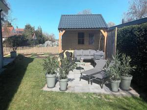 eine Terrasse mit Sofa und Pflanzen im Hinterhof in der Unterkunft Groet Villa Stay with Garden Views in Groet