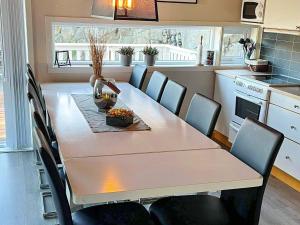 a kitchen with a table and chairs and a table and a table and a kitchen at 4 star holiday home in Auklandshamn in Vestvik