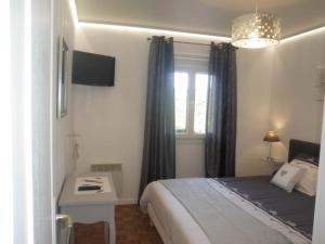 Un dormitorio con una cama y un escritorio y una ventana. en Sea View Family Escape, en Denneville