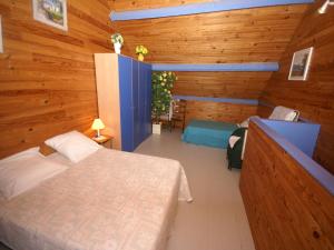 Un dormitorio con una cama en una habitación con paredes de madera. en Sea View Family Escape, en Denneville 22 fotos más