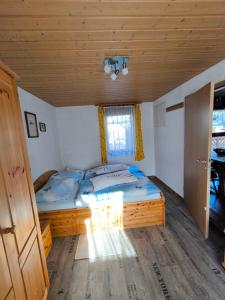 a bed in a room with a wooden ceiling at Haus Sonneneck 2 in Tanna