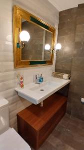 ein Badezimmer mit einem weißen Waschbecken und einem Spiegel in der Unterkunft Primavera Congresos in Granada