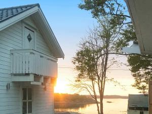 un edificio blanco con una ventana y un árbol en 6 person holiday home in Bjarkøy, en Leirvåg