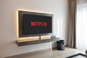 a television on a wall with a netflix sign on it at Luxury Retreat 1BDR Apartment in Yas Island Premium Location with Pool and Gym in Yas Island