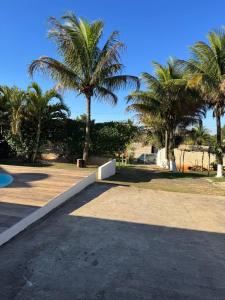 a park with palm trees and a sidewalk at Chacara Oliva in Piracicaba