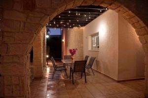 a patio with a table and chairs in a building at Villa Cynthiana 4- 300m from the sea 3 bedrooms 3 bathrooms in Kissonerga