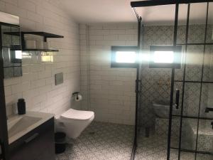 a bathroom with a toilet and a sink and a shower at zevgar bungalov hotel in Ayvacık