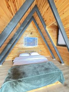 a bed in the attic of a wooden house at zevgar bungalov hotel in Ayvacık