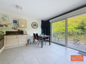 a kitchen with a table and chairs and a balcony at La rose des vents in Wimereux
