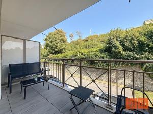 a balcony with a table and a television on it at La rose des vents in Wimereux +15 photos