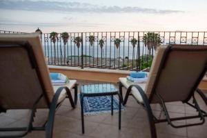 two chairs and a table on a balcony overlooking the ocean at Villa Cynthiana 4- 300m from the sea 3 bedrooms 3 bathrooms in Kissonerga