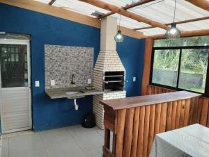 a kitchen with a sink in a blue wall at Spaço Terra hospedagem in Domingos Martins