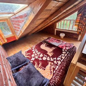 una habitación en el ático con una cama y una alfombra en Hostal Doña Clarita Inn, en Chugchilán 60 fotos más