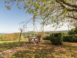 a table and chairs under a canopy of a tree at Historic Tower Home in Brignac in Brignac-la-Plaine