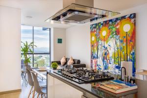 a kitchen with a stove and a painting on the wall at Bizsar 1003 AC Increíbles terrazas y Piscina in Ibagué