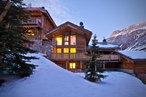 a log cabin in the snow in the mountains at Madame Vacances Chalet Genepy in Val dʼIsère