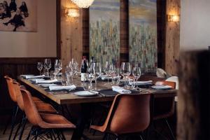 a long table with wine glasses and wine bottles at Madame Vacances Chalet Genepy in Val dʼIsère
