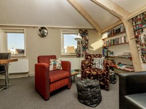 a living room with two chairs and a table at Home with Vinyls, Bikes and Waterways in Mantgum