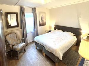 OspelにあるFarmhouse in Nederweert near Canal Trailsのベッドと椅子と窓のある寝室