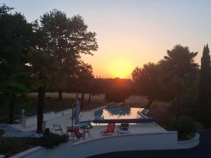 a sunset over a swimming pool with the sun setting at Lola in Saint-Martial-dʼAlbarède +2 photos