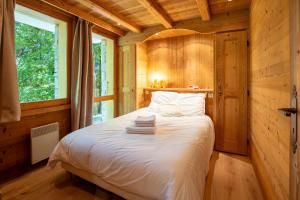 een slaapkamer met een bed in een houten hut bij Fauvettes 2 in Chandon