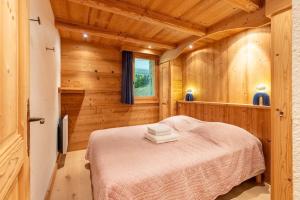 een slaapkamer met een bed in een houten kamer bij Fauvettes 2 in Chandon +7 foto's