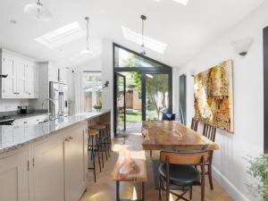 una cucina con un tavolo di legno e alcune sedie di Family Home - Whitton Green Oasis Pass The Keys a Twickenham