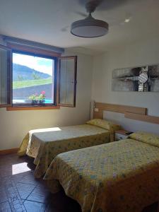 a bedroom with two beds and a window with a view at Casa Rural Amazonas in Sumbilla