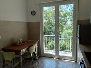 comedor con mesa y puerta corredera de cristal en Villetta Montallegro Rapallo, en San Maurizio del Monte