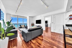 un soggiorno con un divano e un tavolo di South City Suites a Hallandale Beach