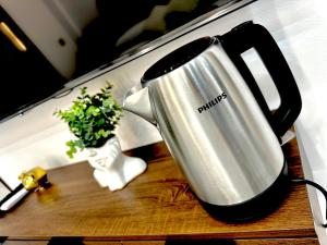 a coffee pot sitting on a table next to a plant at AP Rooms in Almorox