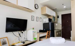 Zimmer mit einem Bett, einem TV und einer Küche in der Unterkunft Studio Apartment Springwood By LyaRoom in Warungmangga