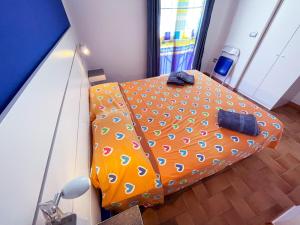 an orange bed with a polka dot sheets in a room at App 2 Studio Wohnung 2 Plätze in Cattolica Eraclea