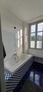 a bath tub in a bathroom with blue and white tiles at Casa di Grazia in Intra +26 photos
