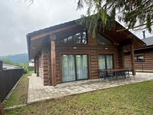 a log cabin with a table in front of it at MoNa chalet in Pavčina Lehota