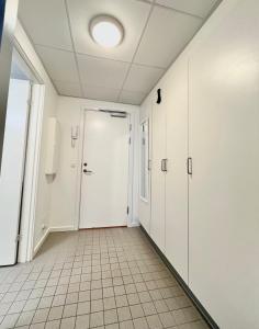 an empty hallway with a door and a tile floor at Central lejlighed i Nuuk in Nuuk +1 photo